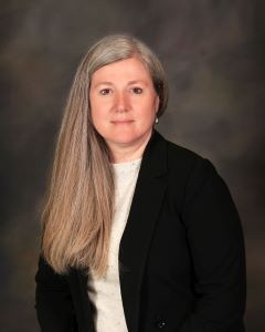 A woman with long hair smiling at the camera.